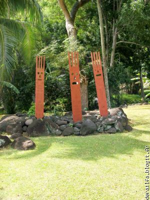 Totems sculptés dans du bois local et peints en rouge